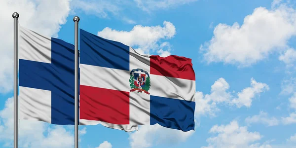 Finland and Dominican Republic flag waving in the wind against white cloudy blue sky together. Diplomacy concept, international relations. — Stock Photo, Image