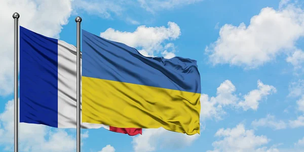 Francie a Ukrajina vlají ve větru proti bíle zatažené modré obloze. Diplomacie, mezinárodní vztahy. — Stock fotografie