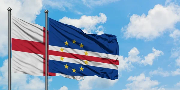 Bandera de Inglaterra y Cabo Verde ondeando en el viento contra el cielo azul nublado blanco juntos. Concepto diplomático, relaciones internacionales . — Foto de Stock