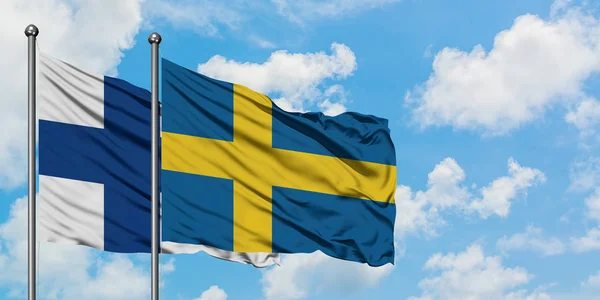 Финляндия и Швеция вместе размахивают на ветру белым облачным голубым небом. Концепция дипломатии, международные отношения . — стоковое фото