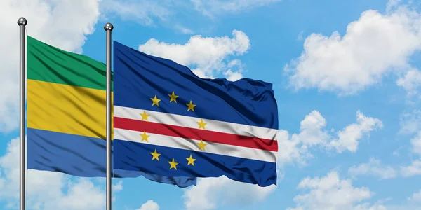 Bandera de Gabón y Cabo Verde ondeando en el viento contra el cielo azul nublado blanco juntos. Concepto diplomático, relaciones internacionales . — Foto de Stock