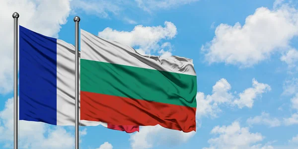 Bandera de Francia y Bulgaria ondeando en el viento contra el cielo azul nublado blanco juntos. Concepto diplomático, relaciones internacionales . — Foto de Stock