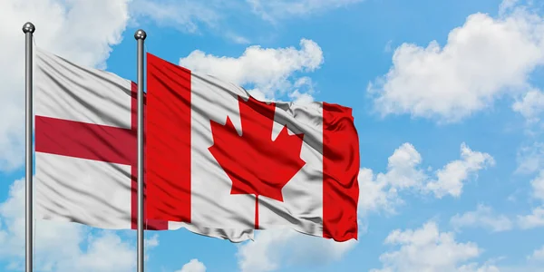 Bandera de Inglaterra y Canadá ondeando en el viento contra el cielo azul nublado blanco juntos. Concepto diplomático, relaciones internacionales . — Foto de Stock