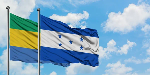 Габону і Гондурас прапор розмахував вітром проти білого хмарного синього неба разом. Концепція дипломатії, міжнародні відносини. — стокове фото