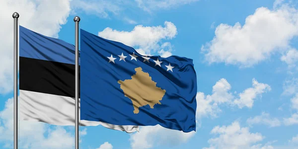 Эстония и флаг Косово вместе размахивают ветром против белого облачного голубого неба. Концепция дипломатии, международные отношения . — стоковое фото