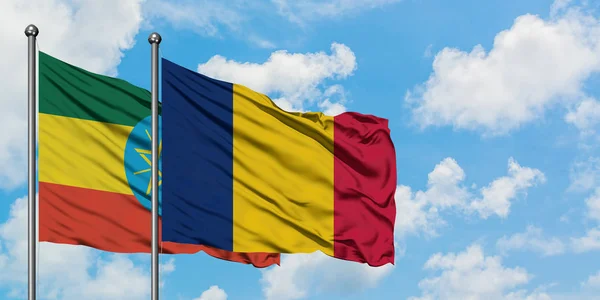 Bandera de Etiopía y Chad ondeando en el viento contra el cielo azul nublado blanco juntos. Concepto diplomático, relaciones internacionales . — Foto de Stock