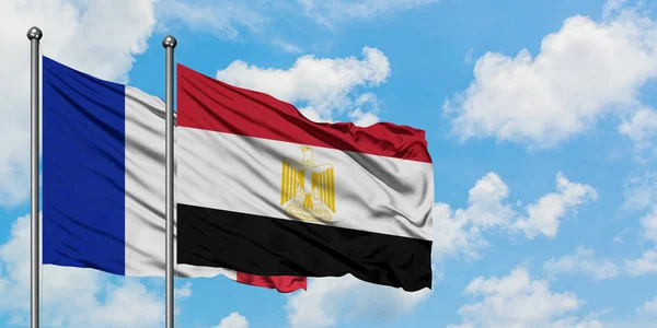 Bandera de Francia y Egipto ondeando en el viento contra el cielo azul nublado blanco juntos. Concepto diplomático, relaciones internacionales . — Foto de Stock