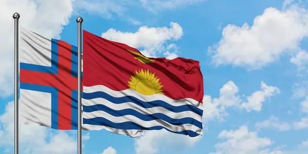 Islas Feroe y la bandera de Kiribati ondeando en el viento contra el cielo azul nublado blanco juntos. Concepto diplomático, relaciones internacionales . — Foto de Stock