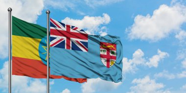 Etiyopya ve Fiji bayrağı birlikte beyaz bulutlu mavi gökyüzüne karşı rüzgarda sallayarak. Diplomasi kavramı, uluslararası ilişkiler.