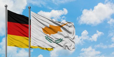 Almanya ve Kıbrıs bayrağı birlikte beyaz bulutlu mavi gökyüzüne karşı rüzgarsal sallayarak. Diplomasi kavramı, uluslararası ilişkiler.