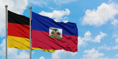 Almanya ve Haiti bayrağı birlikte beyaz bulutlu mavi gökyüzüne karşı rüzgarda sallayarak. Diplomasi kavramı, uluslararası ilişkiler.