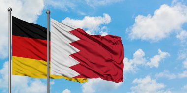 Almanya ve Bahreyn bayrağı birlikte beyaz bulutlu mavi gökyüzüne karşı rüzgarsal sallayarak. Diplomasi kavramı, uluslararası ilişkiler.