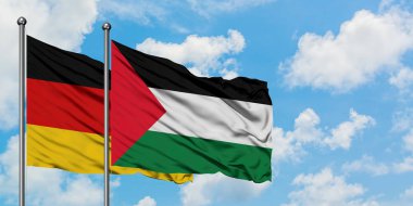 Almanya ve Filistin bayrağı birlikte beyaz bulutlu mavi gökyüzüne karşı rüzgarda sallayarak. Diplomasi kavramı, uluslararası ilişkiler.