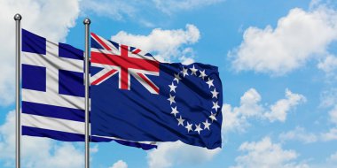 Yunanistan ve Cook Adaları bayrağı birlikte beyaz bulutlu mavi gökyüzüne karşı rüzgarsal sallayarak. Diplomasi kavramı, uluslararası ilişkiler.