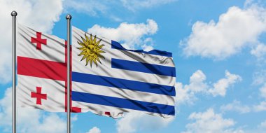Gürcistan ve Uruguay bayrağı birlikte beyaz bulutlu mavi gökyüzüne karşı rüzgarsal sallayarak. Diplomasi kavramı, uluslararası ilişkiler.