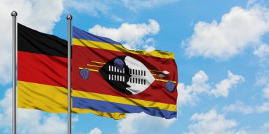 Almanya ve Svaziland bayrağı birlikte beyaz bulutlu mavi gökyüzüne karşı rüzgarda sallayarak. Diplomasi kavramı, uluslararası ilişkiler.