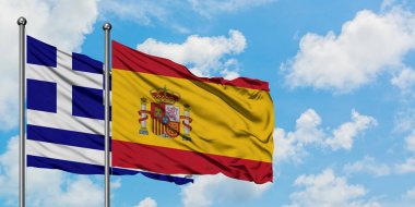 Yunanistan ve İspanya bayrağı birlikte beyaz bulutlu mavi gökyüzüne karşı rüzgarsal sallayarak. Diplomasi kavramı, uluslararası ilişkiler.