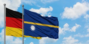 Almanya ve Nauru bayrağı birlikte beyaz bulutlu mavi gökyüzüne karşı rüzgarda sallayarak. Diplomasi kavramı, uluslararası ilişkiler.