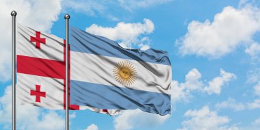 Gürcistan ve Arjantin bayrağı birlikte beyaz bulutlu mavi gökyüzüne karşı rüzgarda sallayarak. Diplomasi kavramı, uluslararası ilişkiler.