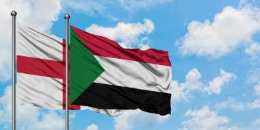 İngiltere ve Sudan bayrağı birlikte beyaz bulutlu mavi gökyüzüne karşı rüzgarda sallayarak. Diplomasi kavramı, uluslararası ilişkiler.