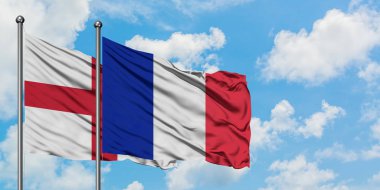 İngiltere ve Reunion bayrağı birlikte beyaz bulutlu mavi gökyüzüne karşı rüzgarda sallayarak. Diplomasi kavramı, uluslararası ilişkiler.