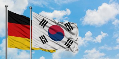 Almanya ve Güney Kore bayrağı birlikte beyaz bulutlu mavi gökyüzüne karşı rüzgarsal sallayarak. Diplomasi kavramı, uluslararası ilişkiler.