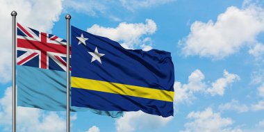 Fiji ve Curacao bayrağı birlikte beyaz bulutlu mavi gökyüzüne karşı rüzgarda sallayarak. Diplomasi kavramı, uluslararası ilişkiler.