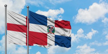 İngiltere ve Dominik Cumhuriyeti bayrağı birlikte beyaz bulutlu mavi gökyüzüne karşı rüzgarda sallayarak. Diplomasi kavramı, uluslararası ilişkiler.