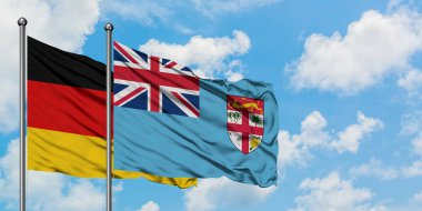 Almanya ve Fiji bayrağı birlikte beyaz bulutlu mavi gökyüzüne karşı rüzgarda sallayarak. Diplomasi kavramı, uluslararası ilişkiler.