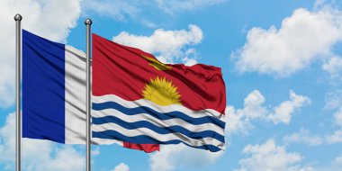 Fransa ve Kiribati bayrağı birlikte beyaz bulutlu mavi gökyüzüne karşı rüzgarda sallayarak. Diplomasi kavramı, uluslararası ilişkiler.