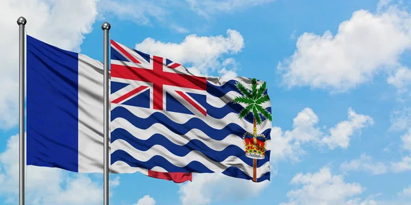 Frankrike och brittiska Indiska oceanen territorium flagga vifta i vinden mot vit grumlig blå himmel tillsammans. Diplomatisk koncept, internationella relationer. — Stockfoto