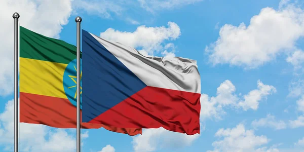 Etiopía y República Checa bandera ondeando en el viento contra el cielo azul nublado blanco juntos. Concepto diplomático, relaciones internacionales . — Foto de Stock