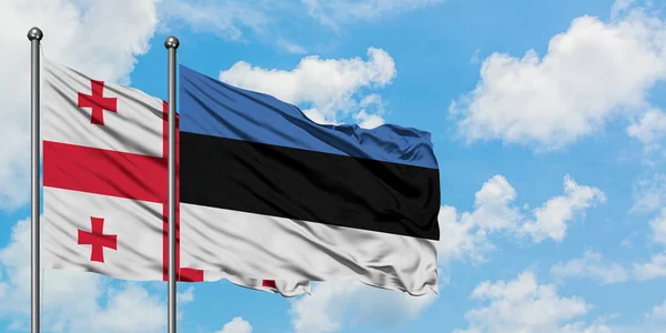 Грузія і Естонія прапор розмахуючи на вітрі проти білого хмарного синього неба разом. Концепція дипломатії, міжнародні відносини. — стокове фото