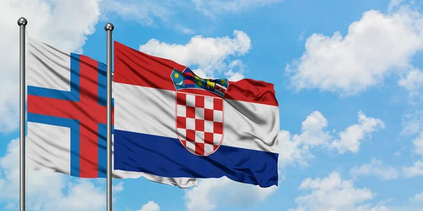 Bandera de las Islas Feroe y Croacia ondeando en el viento contra el cielo azul nublado blanco juntos. Concepto diplomático, relaciones internacionales . — Foto de Stock