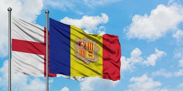 Bandera de Inglaterra y Andorra ondeando en el viento contra el cielo azul nublado blanco juntos. Concepto diplomático, relaciones internacionales . — Foto de Stock