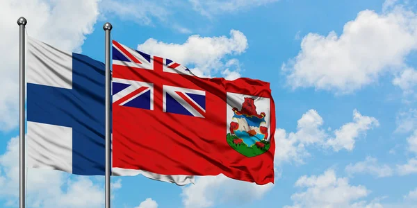 Bandera de Finlandia y Bermudas ondeando en el viento contra el cielo azul nublado blanco juntos. Concepto diplomático, relaciones internacionales . —  Fotos de Stock