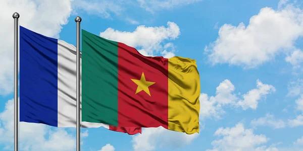 Bandera de Francia y Camerún ondeando en el viento contra el cielo azul nublado blanco juntos. Concepto diplomático, relaciones internacionales . — Foto de Stock