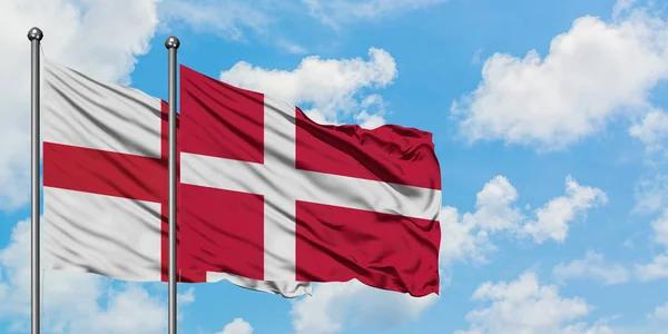 Anglie a Dánská vlajka mávali větrem ve větru proti bíle zatažené modré obloze. Diplomacie, mezinárodní vztahy. — Stock fotografie