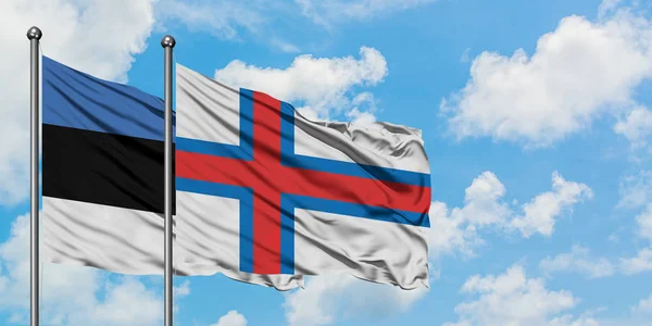 爱沙尼亚和法罗群岛国旗在风中飘扬，与白云相间的蓝天相一起。外交概念、国际关系. — 图库照片