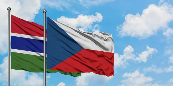 Gambie a Česká republika vlají ve větru proti bíle zatažené modré obloze. Diplomacie, mezinárodní vztahy. — Stock fotografie