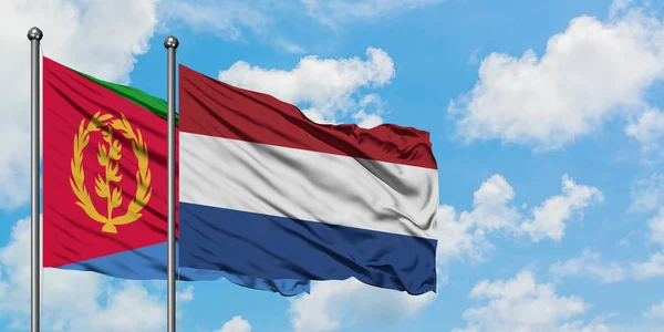 厄立特里亚和荷兰国旗在风中飘扬，白云蓝天相聚。外交概念、国际关系. — 图库照片