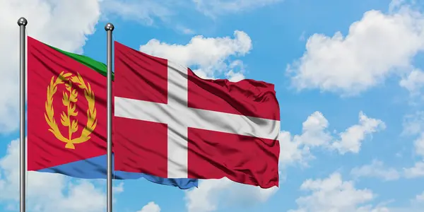 L'Érythrée et le Danemark battent ensemble dans le vent contre un ciel bleu nuageux blanc. Concept de diplomatie, relations internationales . — Photo