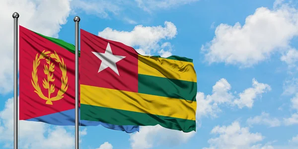 Eritrea and Togo flag waving in the wind against white cloudy blue sky together. Diplomacy concept, international relations. — Stock Photo, Image