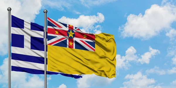 Řecko a Niue vlajka mávali ve větru proti bíle zatažené modré obloze. Diplomacie, mezinárodní vztahy. — Stock fotografie
