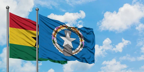 Bandera de Ghana y las Islas Marianas del Norte ondeando en el viento contra el cielo azul nublado blanco juntos. Concepto diplomático, relaciones internacionales . — Foto de Stock