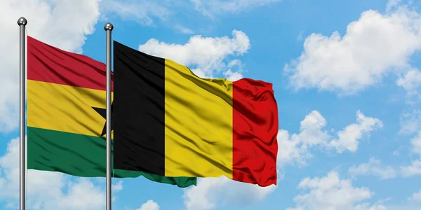 Ghana i Belgia flaga machając w wiatr przed białym zachmurzone błękitne niebo razem. Koncepcja dyplomacji, stosunki międzynarodowe. — Zdjęcie stockowe