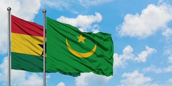 Bandera de Ghana y Mauritania ondeando en el viento contra el cielo azul nublado blanco juntos. Concepto diplomático, relaciones internacionales . — Foto de Stock