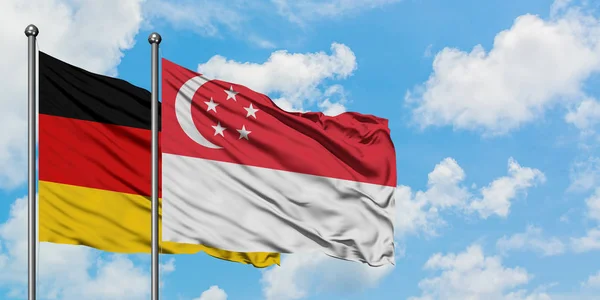 Germany and Singapore flag waving in the wind against white cloudy blue sky together. Diplomacy concept, international relations. — Stock Photo, Image