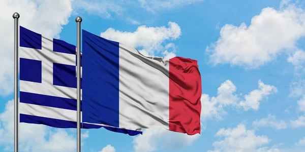 希腊和法国国旗在风中飘扬，白云蓝天相拥。外交概念、国际关系. — 图库照片