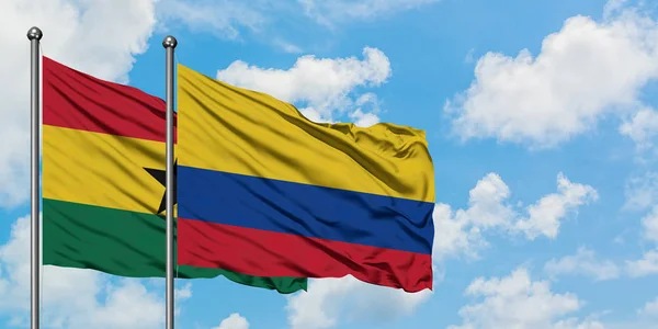 Ghana en Colombia vlag zwaaien in de wind tegen witte bewolkte blauwe hemel samen. Diplomatie concept, internationale betrekkingen. — Stockfoto